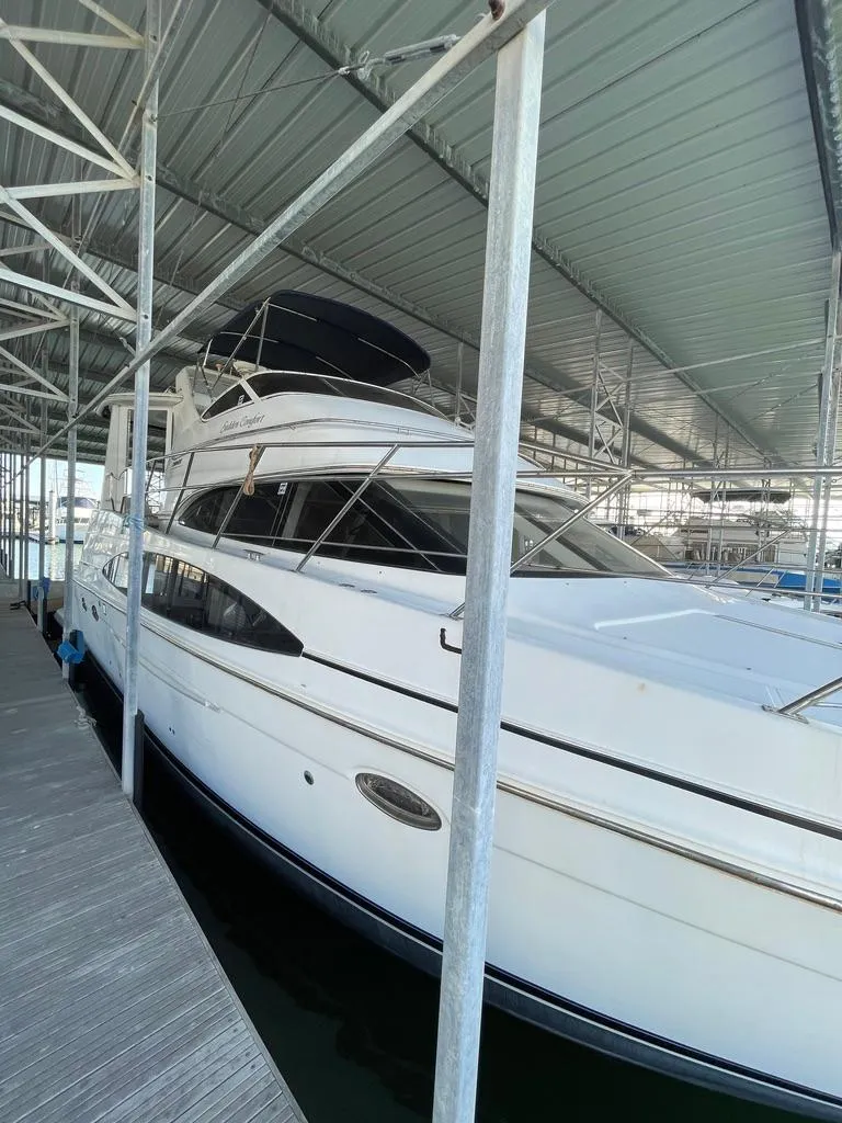 Slide: The Image of 2001 Carver 444 Cockpit Motor Yacht docked under a covered marina. - 12
