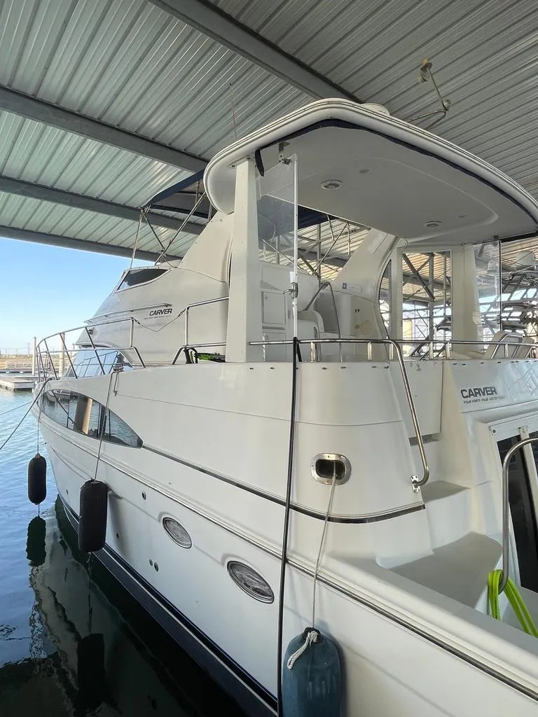 Slide: The Image of 2001 Carver 444 Cockpit Motor Yacht docked under shelter. - 14