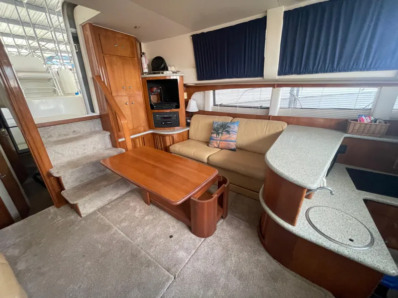 Slide: The Image of 2001 Carver 444 Cockpit Motor Yacht interior with sofa, table, and kitchenette. - 37