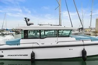 Slide: The Image of 2023 Axopar 37 boat docked in marina, featuring sleek design and modern outboard engine. - 3