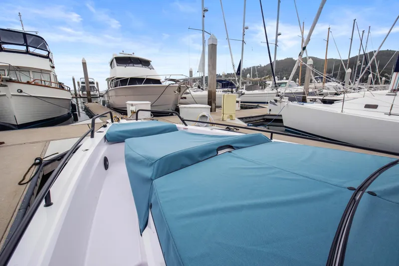 Slide: The Image of 2023 Axopar 37 boat docked at marina with blue covers, surrounded by yachts. - 34