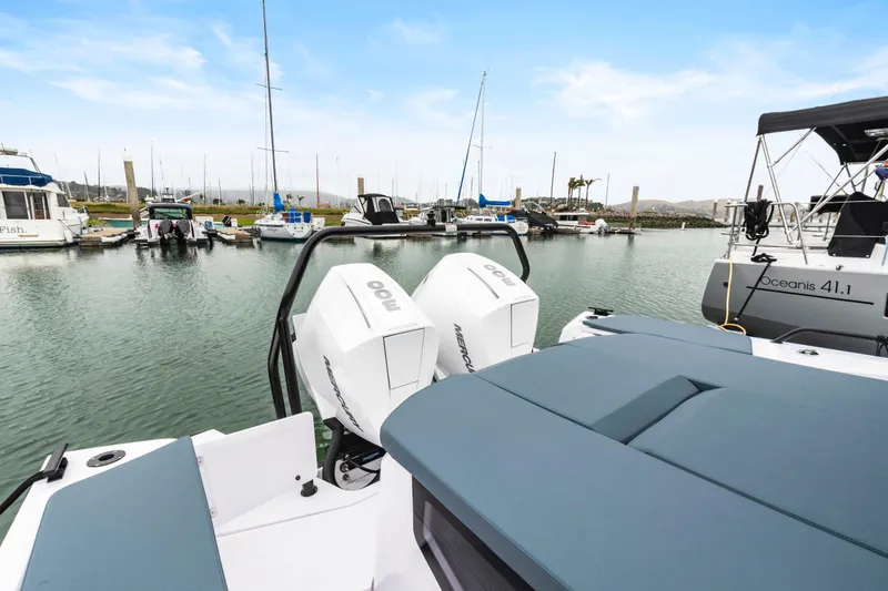 Slide: The Image of 2023 Axopar 37 boat with twin outboard engines docked in a marina. - 37