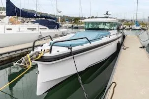 Slide: The Image of 2023 Axopar 37 boat docked in marina, featuring sleek design and blue cover. - 7