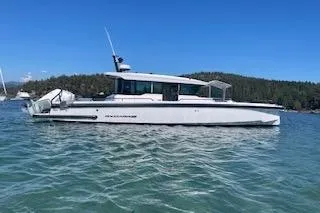 The Image of 2023 Axopar 37 boat docked in marina, surrounded by sailboats under a clear sky. - 0