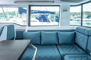 Slide: The Image of Luxurious interior of 2023 Axopar 37 boat with blue seating and marina view. - 16