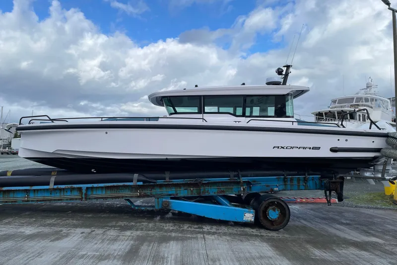 Slide: The Image of 2023 Axopar 37 boat on trailer under cloudy sky at marina. - 32