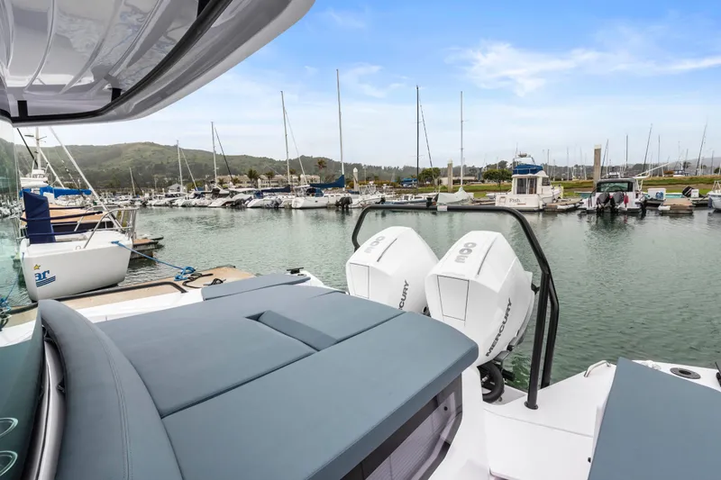 Slide: The Image of 2023 Axopar 37 boat docked in a marina with twin Mercury engines. - 36