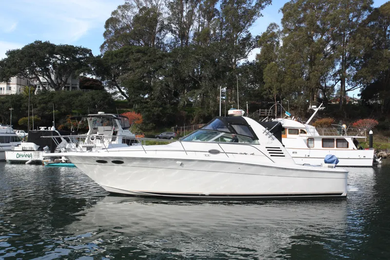 The Image of 1997 Sea Ray 330 Express Cruiser docked in a serene marina setting. - 0