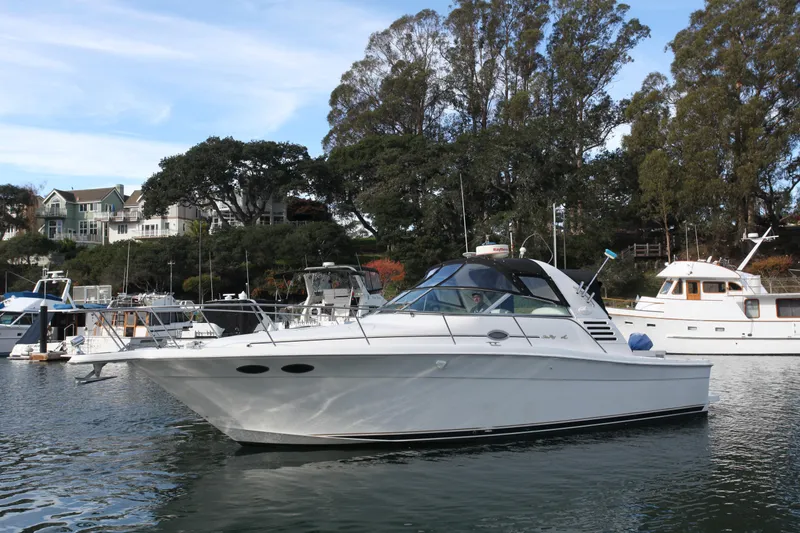 Slide: The Image of 1997 Sea Ray 330 Express Cruiser docked in a scenic marina setting. - 22