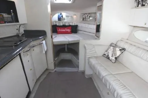 Slide: The Image of 1997 Sea Ray 330 Express Cruiser interior with white seating and compact kitchen area. - 30