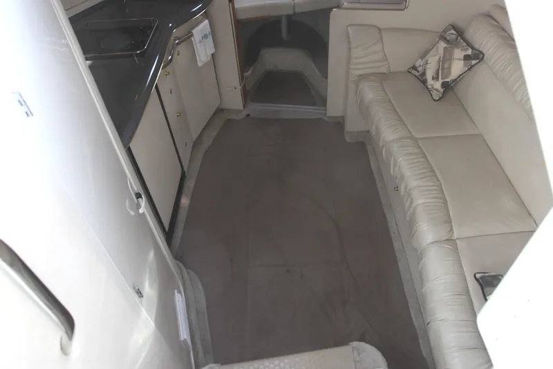 Slide: The Image of Interior of 1997 Sea Ray 330 Express Cruiser with beige seating and compact kitchen area. - 5