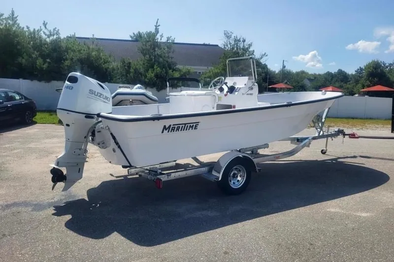 Slide: The Image of 2024 Maritime 2090 Skiff boat with Suzuki engine on trailer, parked outdoors. - 3