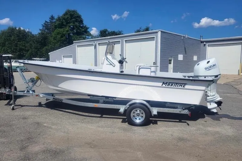 Slide: The Image of 2024 Maritime 2090 Skiff boat on trailer, parked outdoors near industrial buildings. - 6