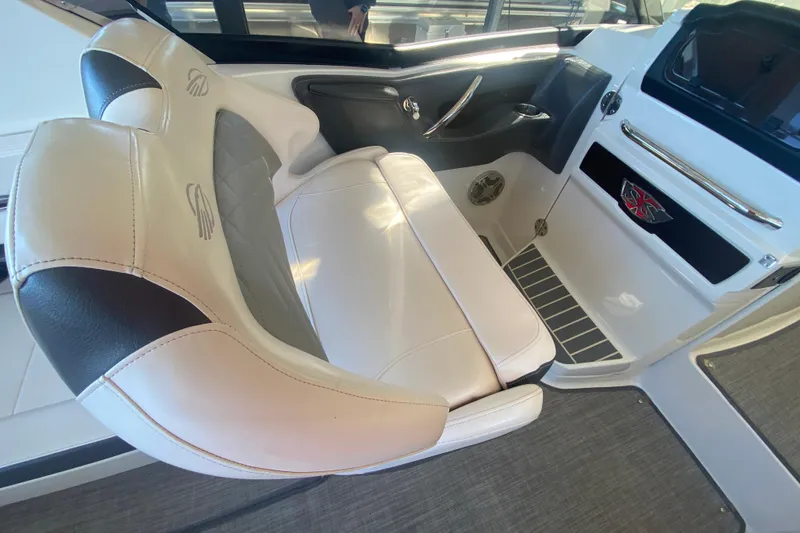 Slide: The Image of 2018 Chaparral 337 SSX boat interior with white leather seating and modern dashboard. - 19