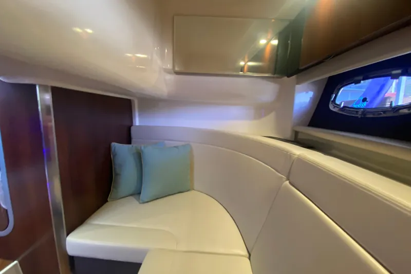 Slide: The Image of 2018 Chaparral 337 SSX cabin interior with white seating and blue cushions. - 25