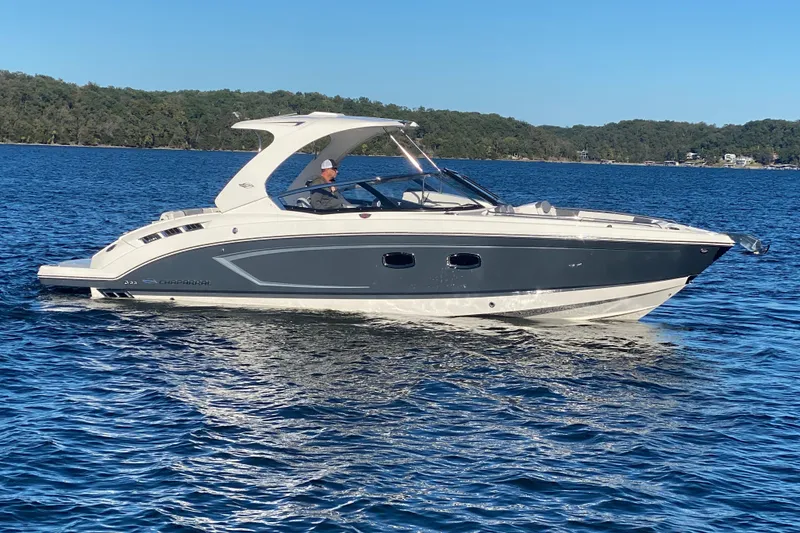 Slide: The Image of 2018 Chaparral 337 SSX boat cruising on a serene lake with forested shoreline. - 5