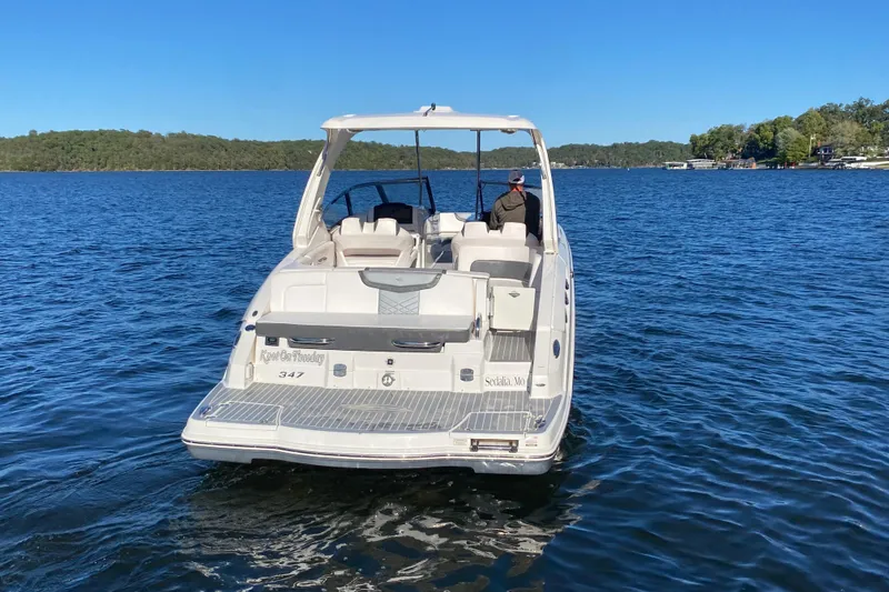 Slide: The Image of 2018 Chaparral 337 SSX boat cruising on a serene lake under clear blue skies. - 52