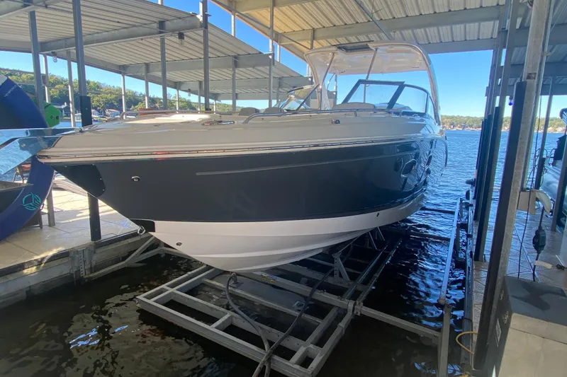 Slide: The Image of 2018 Chaparral 337 SSX boat docked under a covered marina on a sunny day. - 6
