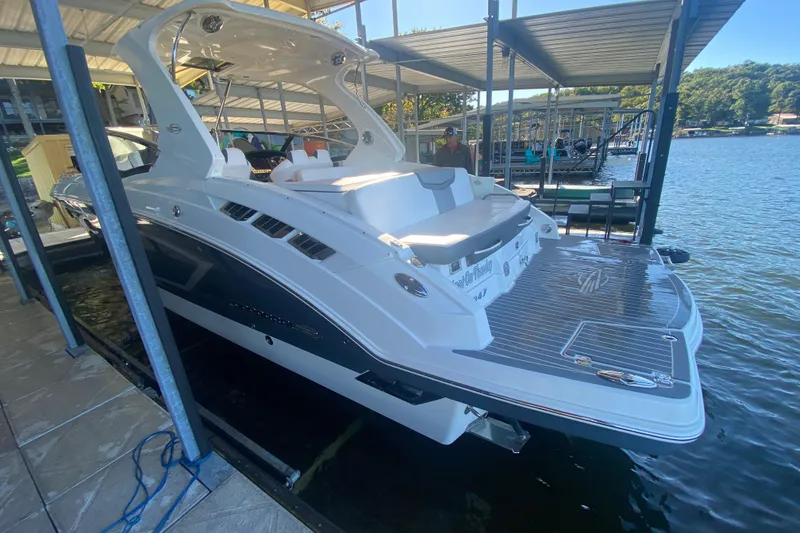 Slide: The Image of 2018 Chaparral 337 SSX boat docked at a marina, featuring sleek design and spacious deck. - 7