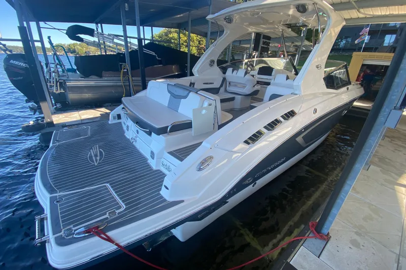 Slide: The Image of 2018 Chaparral 337 SSX boat docked, showcasing sleek design and spacious deck. - 9