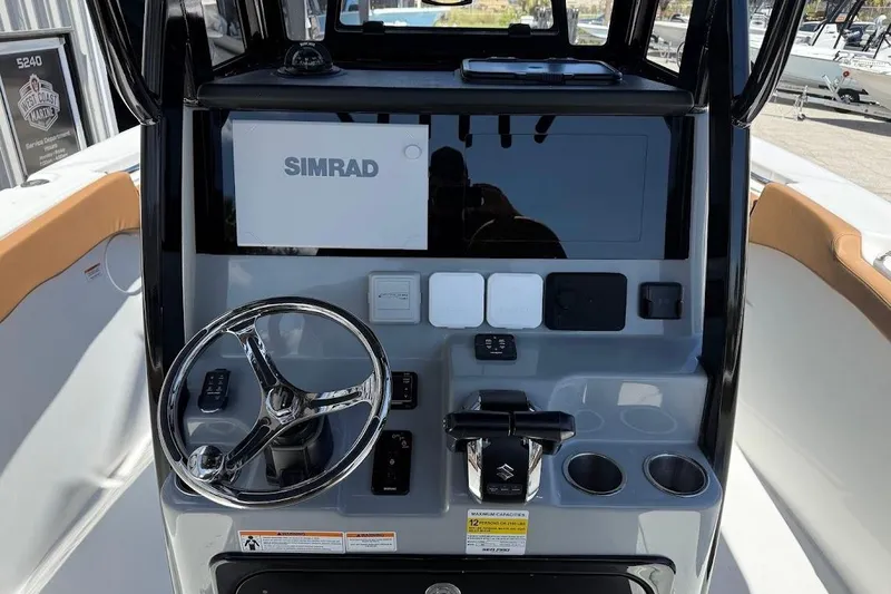 Slide: The Image of 2026 Sea Pro 262 Offshore boat dashboard with Simrad display and steering wheel. - 19