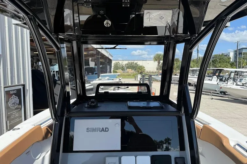 Slide: The Image of 2026 Sea Pro 262 Offshore boat interior with Simrad navigation system, docked at marina. - 20