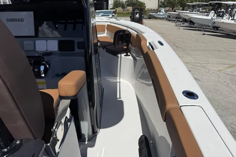 Slide: The Image of 2026 Sea Pro 262 Offshore boat interior with brown seating and Simrad electronics. - 23