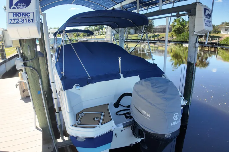 Slide: The Image of 2020 NauticStar 243 DC boat docked with Yamaha engine cover, under blue canopy. - 16