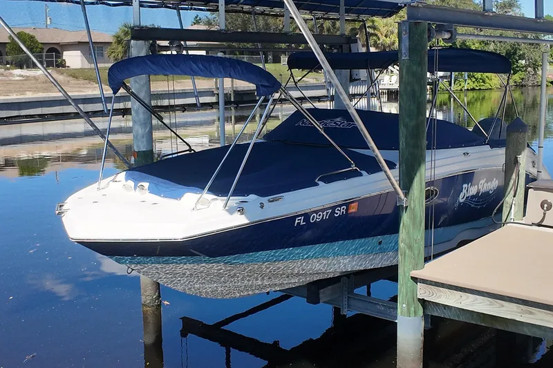 Slide: The Image of 2020 NauticStar 243 DC boat docked, covered, and elevated on a lift. - 17