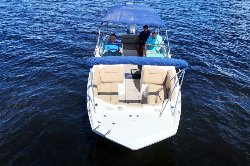 Slide: The Image of 2020 NauticStar 243 DC boat on water with passengers, featuring a blue canopy. - 3