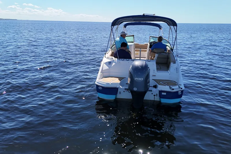 Slide: The Image of 2020 NauticStar 243 DC boat on open water with three people onboard. - 4