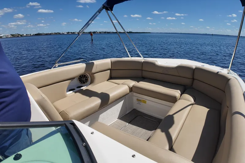 Slide: The Image of 2020 NauticStar 243 DC boat interior with beige seating on a sunny day. - 7