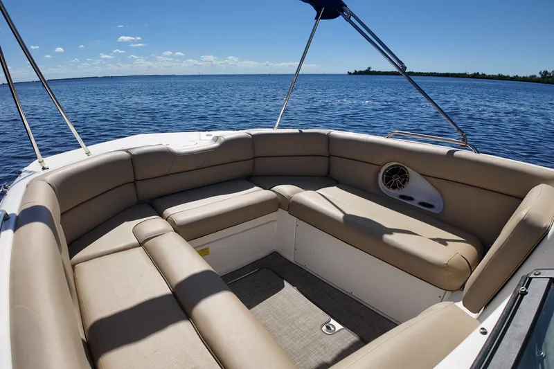 Slide: The Image of 2020 NauticStar 243 DC boat interior with beige seating, overlooking calm blue water. - 8