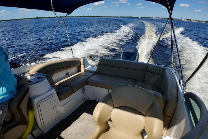 Slide: The Image of 2020 NauticStar 243 DC boat interior with seating, cruising on open water. - 9