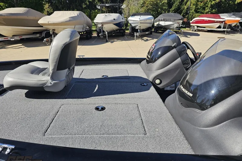 Slide: The Image of 2018 Tracker Pro Team 175 TXW boat interior with seating and dashboard, surrounded by other boats. - 28
