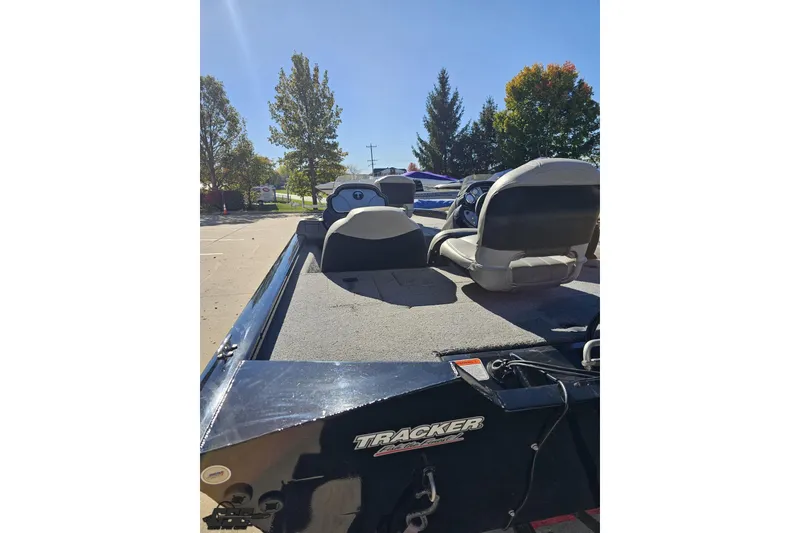 Slide: The Image of 2018 Tracker Pro Team 175 TXW boat with seating, parked outdoors under clear sky. - 37