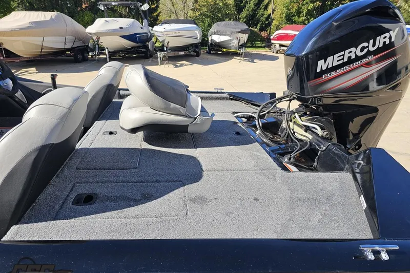 Slide: The Image of 2018 Tracker Pro Team 175 TXW boat with Mercury engine, parked among other boats. - 63