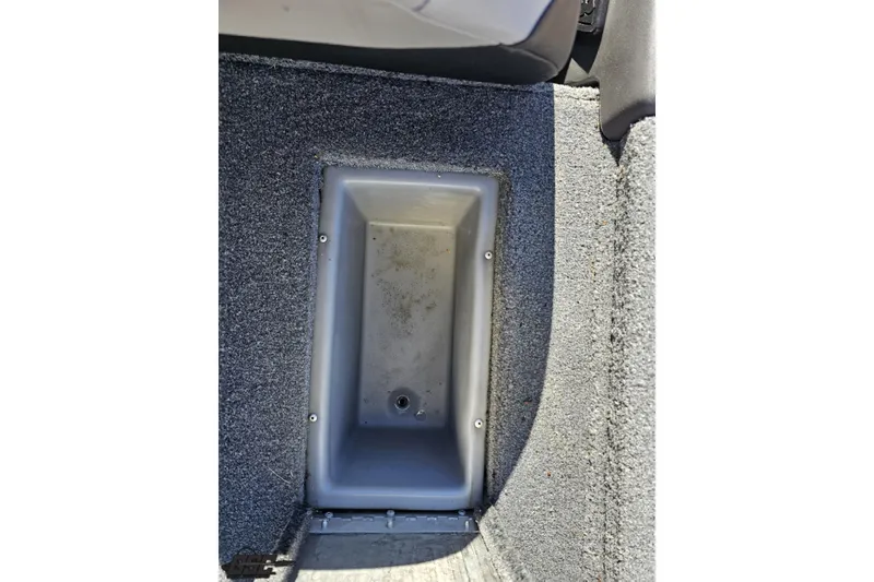 Slide: The Image of 2018 Tracker Pro Team 175 TXW boat storage compartment, gray interior, carpeted edges. - 65