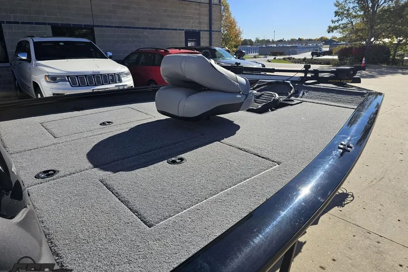 Slide: The Image of 2018 Tracker Pro Team 175 TXW boat with carpeted deck and seat, parked outdoors. - 8