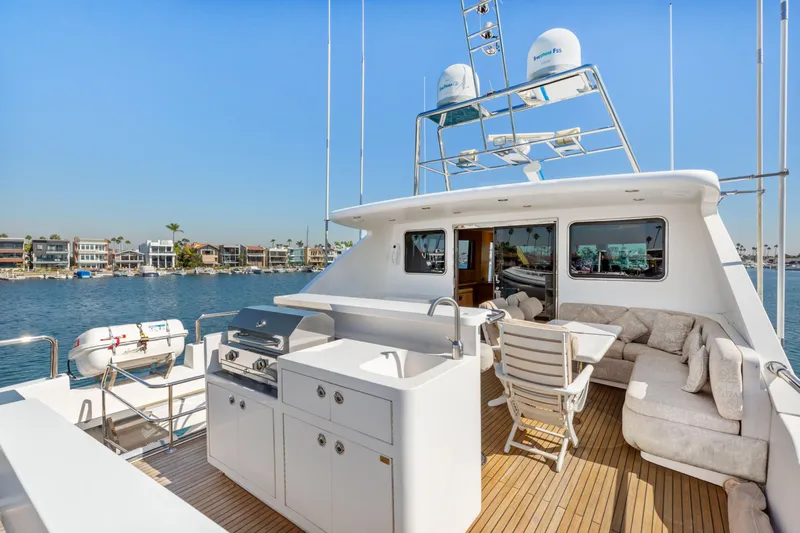 Slide: The Image of Luxurious 2005 Custom yacht deck with seating, overlooking serene waterfront and palm trees. - 20