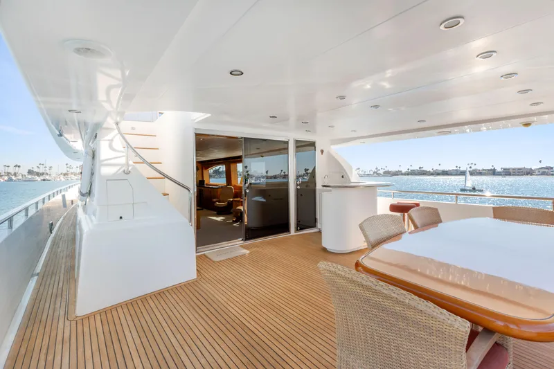 Slide: The Image of Luxurious yacht deck with wicker furniture, overlooking a scenic waterfront view. - 31