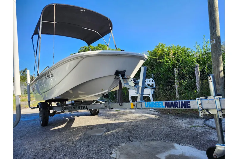 Slide: The Image of 2020 Boston Whaler 110 Sport on trailer with canopy, parked outdoors. - 15