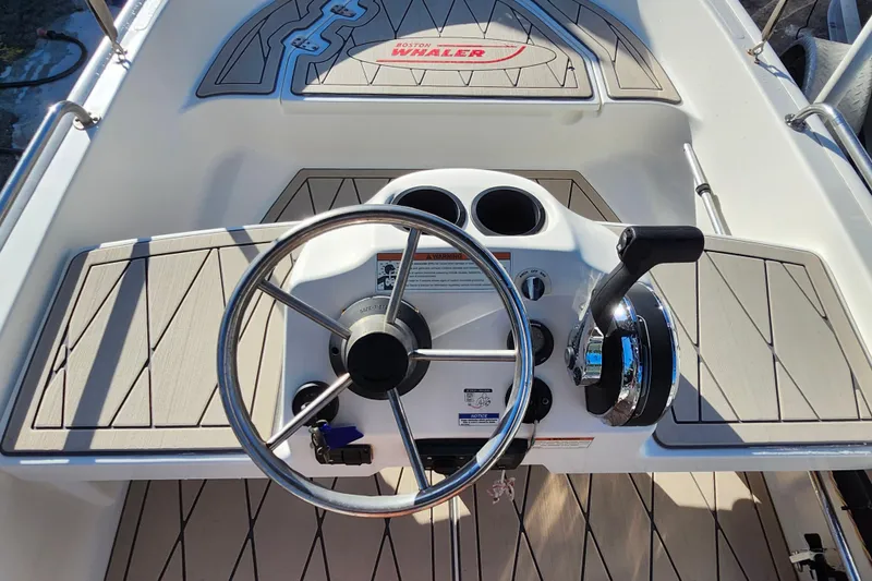 Slide: The Image of 2020 Boston Whaler 110 Sport steering console with wheel and throttle controls. - 7