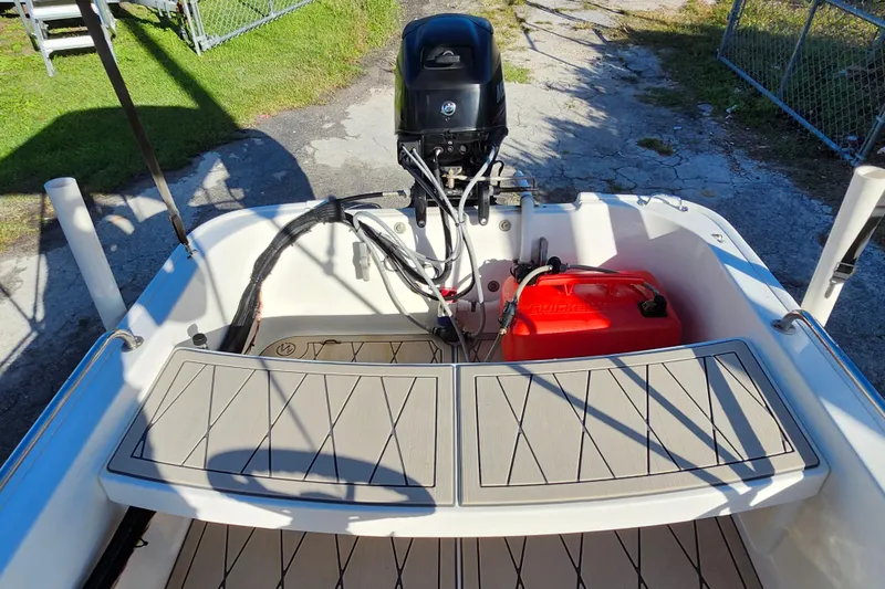 Slide: The Image of 2020 Boston Whaler 110 Sport boat with outboard motor and red fuel tank. - 9