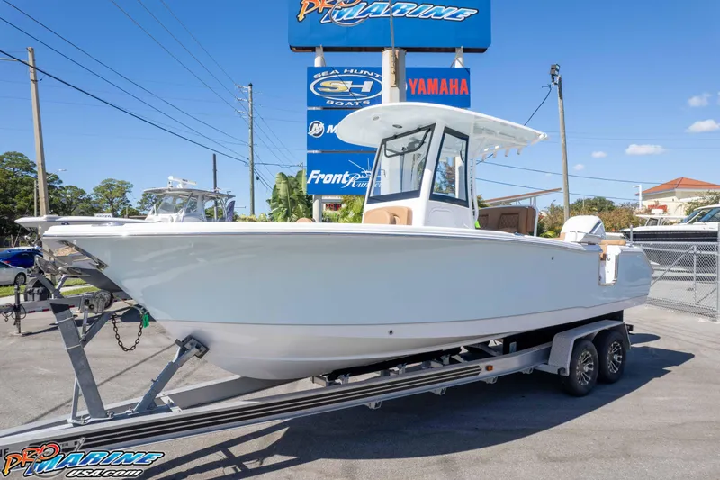 The Image of 2026 Sea Hunt Ultra 255 SE boat on trailer at dealership under clear blue sky. - 0
