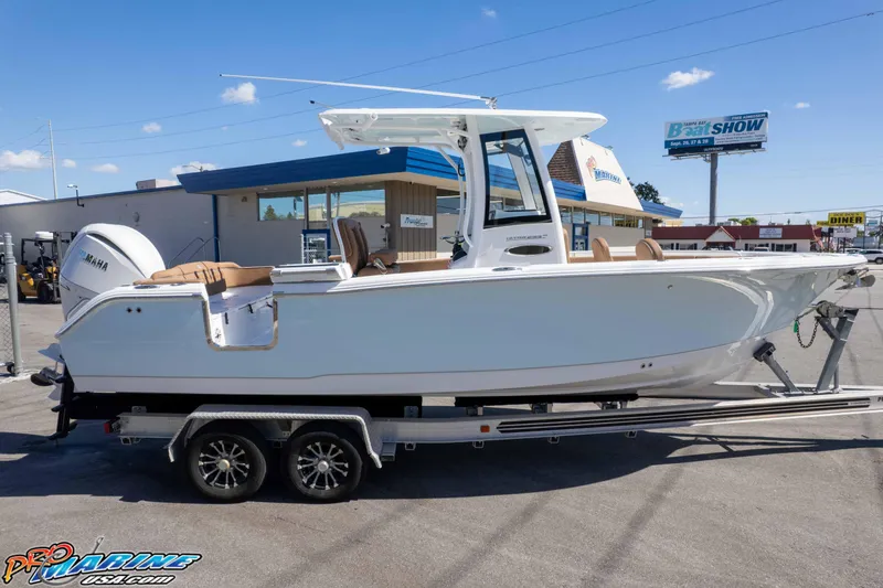 Slide: The Image of 2026 Sea Hunt Ultra 255 SE boat on trailer at dealership under clear sky. - 16