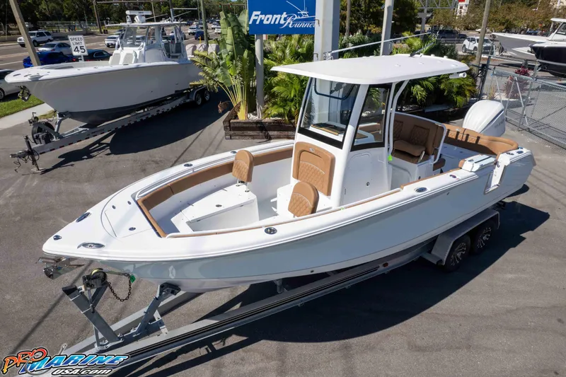 Slide: The Image of 2026 Sea Hunt Ultra 255 SE boat on trailer at dealership, featuring sleek design and spacious seating. - 2