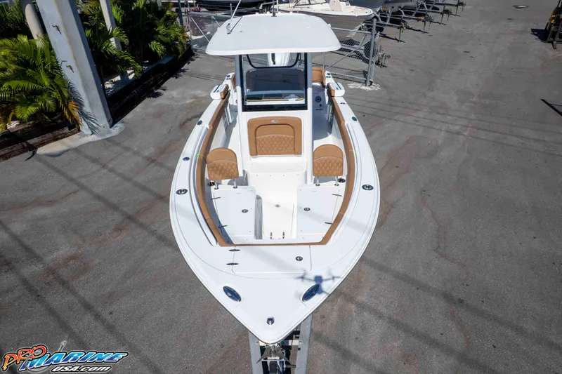 Slide: The Image of 2026 Sea Hunt Ultra 255 SE boat, white with tan seating, docked outdoors. - 22