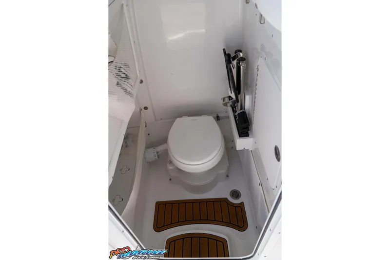 Slide: The Image of 2026 Sea Hunt Ultra 255 SE boat interior with compact marine toilet and wooden floor accents. - 42