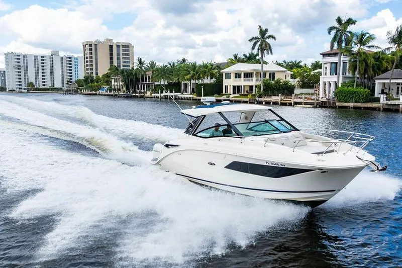 Slide: The Image of 2021 Sea Ray Sundancer 320 Outboard cruising on a scenic waterway with luxury homes. - 15